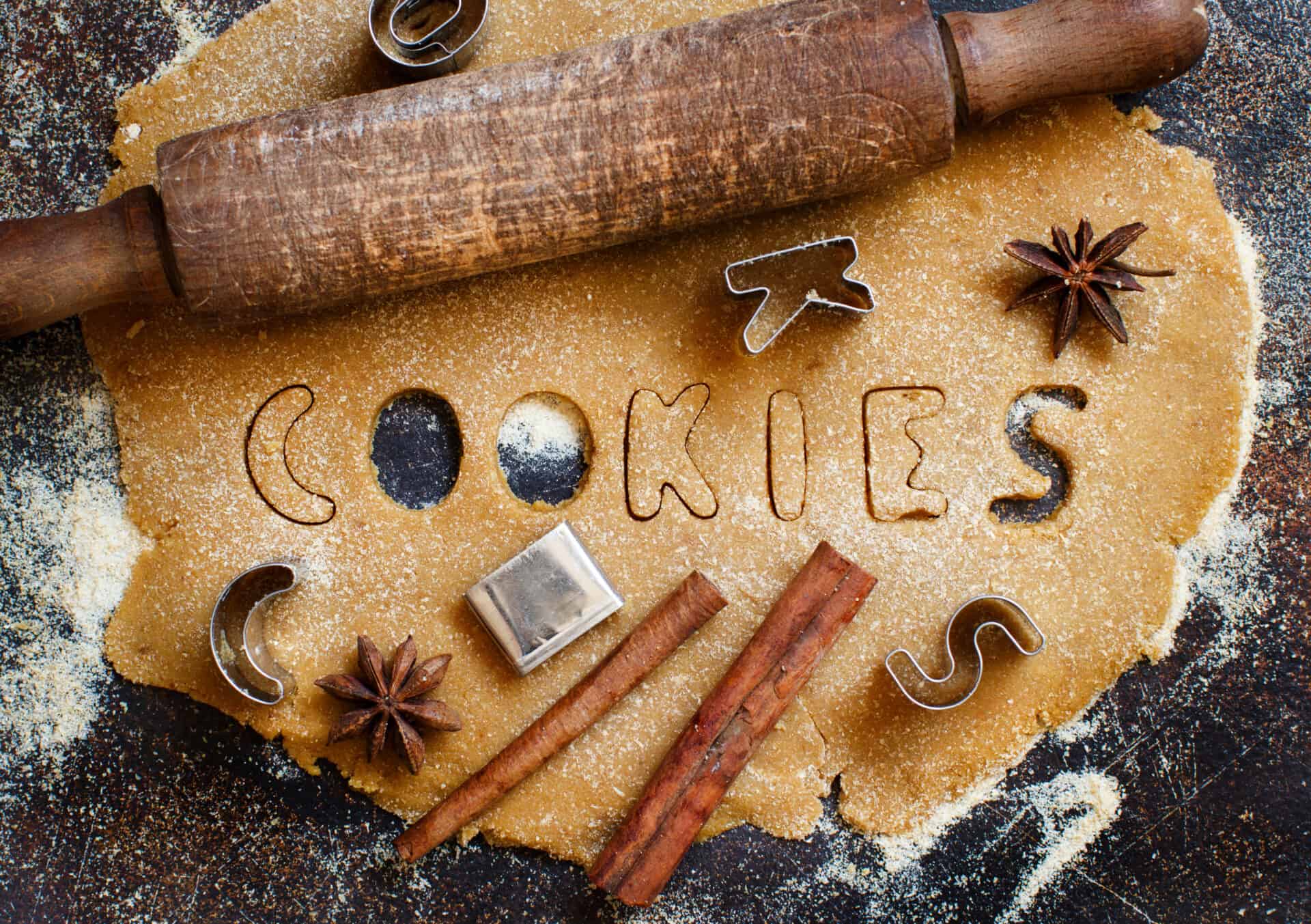 Making cookie letters in a dough on a dark table